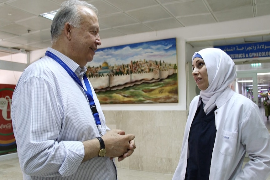 Makassad Hospital director Rafik Husseini talks to one of his staff in a hospital corridor.