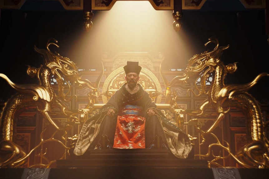 A scene from the movie Mulan with Jet Li as a Chinese emperor sitting on a golden throne