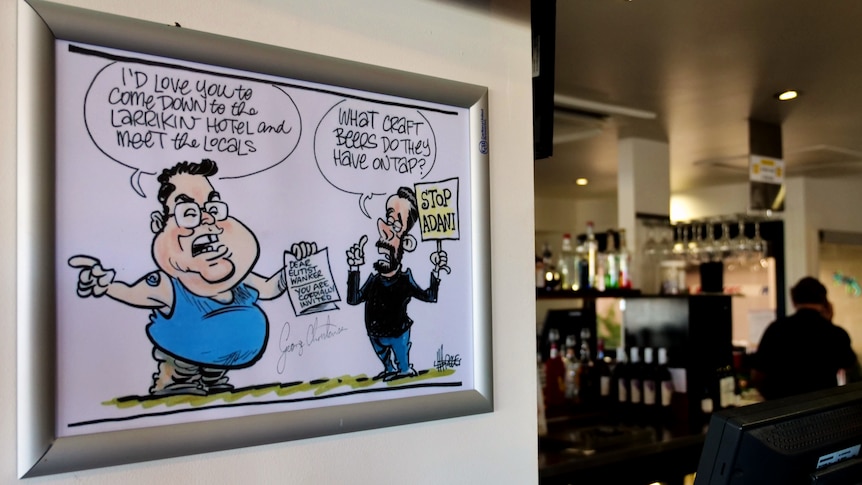 on the wall of a pub is a cartoon that shows goerge christensen inviting a stop adani protestor to meet Bowen locals