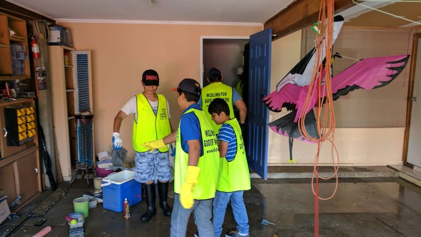 Children from the Ahmadiyya Muslim Community help clean a house