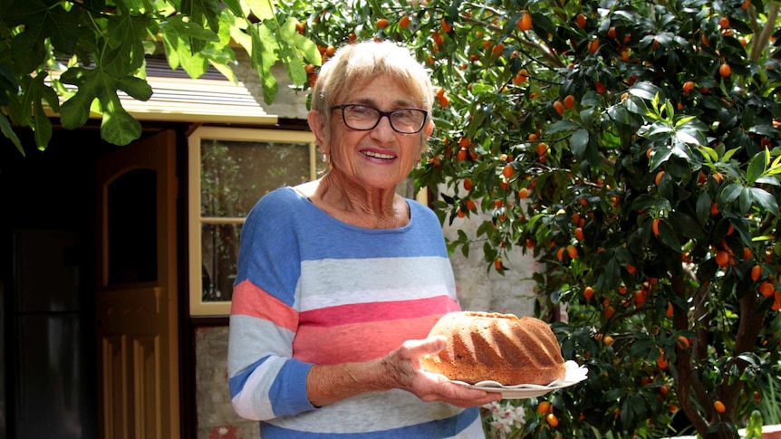 82 year old Judy Kolt stands in her garden holding a Polish version of the babka cake.