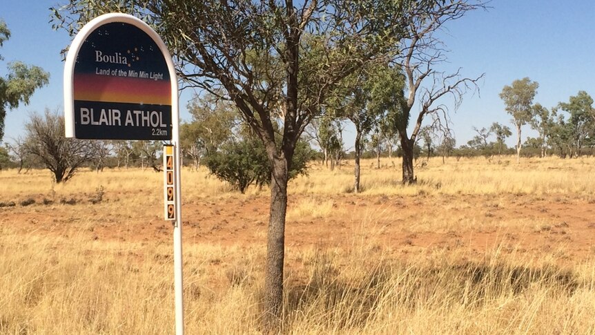 Dry grass, near a sign for the Blair Athol station.
