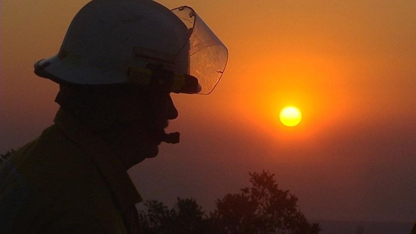 A silhouetted firefighter against the red sunset