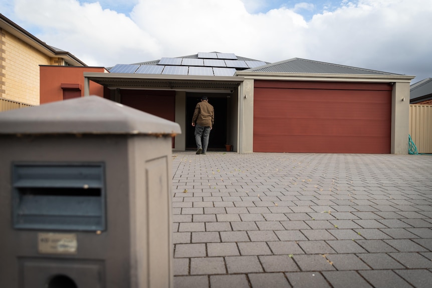 A man out the front of a bungalow home