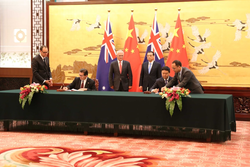 Prime Minister Malcolm Turnbull stands side-by-side with Premier Li Keqiang at a signing ceremony in China.