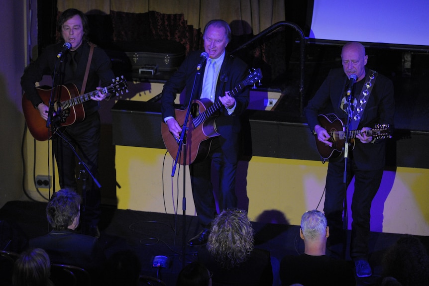 Glenn Wheatley performs with two others at the funeral of the Masters and Apprentices singer in 2014. 