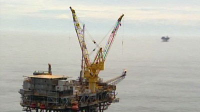 Aerial shot of an oil rig in the ocean.