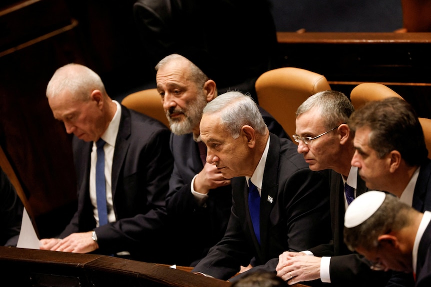 Benjamin Netanyahu and members of his government look on from parliament room balcony.