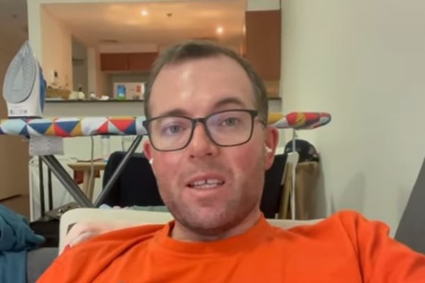 a man wearing glasses sitting on a lounge