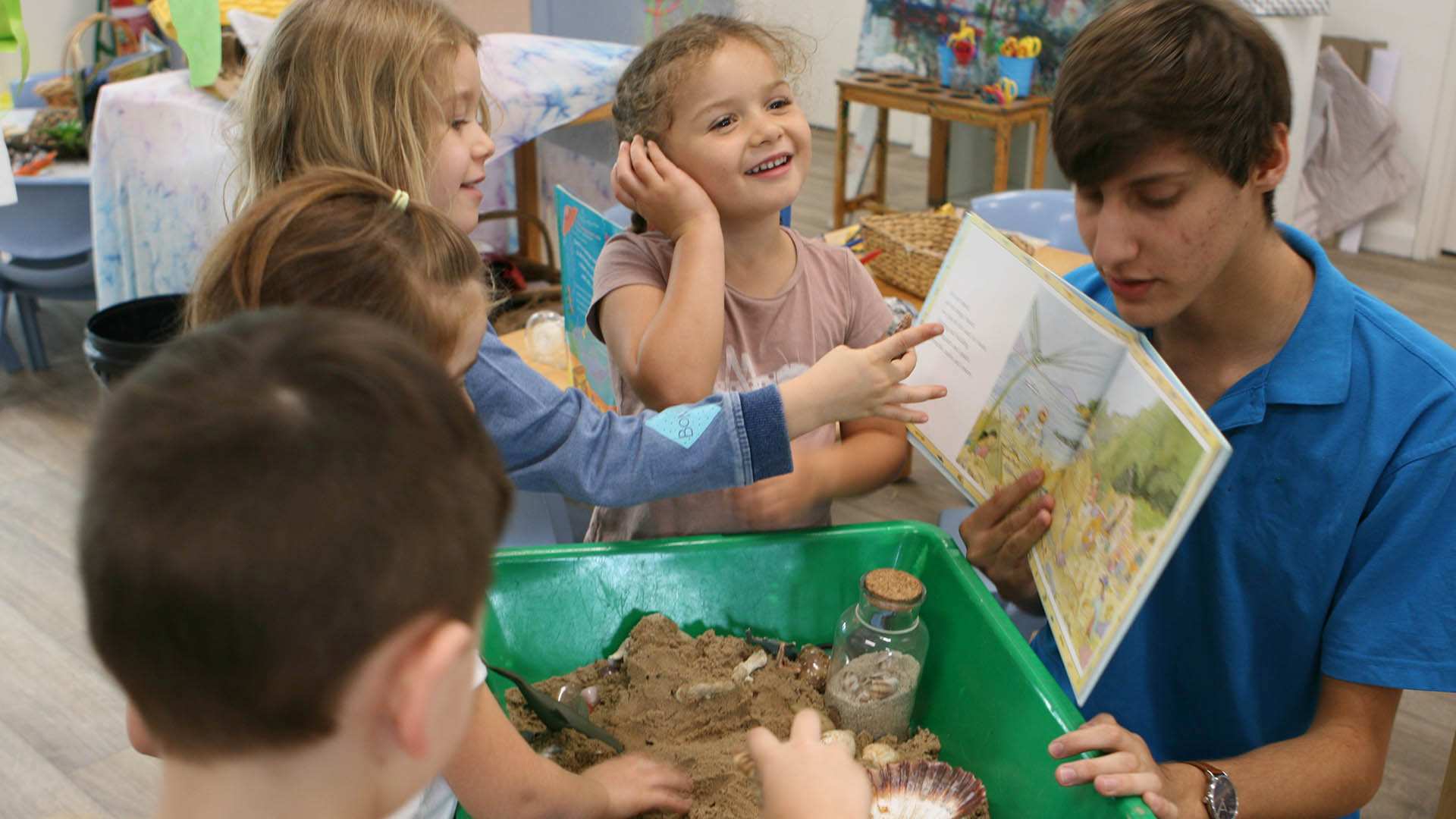 Educator in a classroom reading a book to children