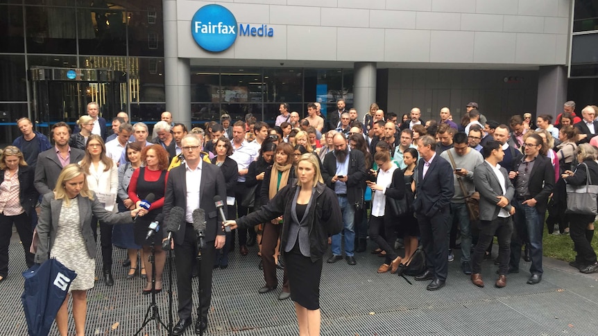 The Sydney Morning Herald state political editor Sean Nicholls stands in front of colleagues and the Sydney Fairfax office.