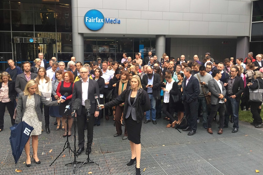 The Sydney Morning Herald state political editor Sean Nicholls stands in front of colleagues and the Sydney Fairfax office.