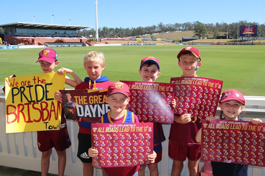 Children hold up Brisbane Lions signs