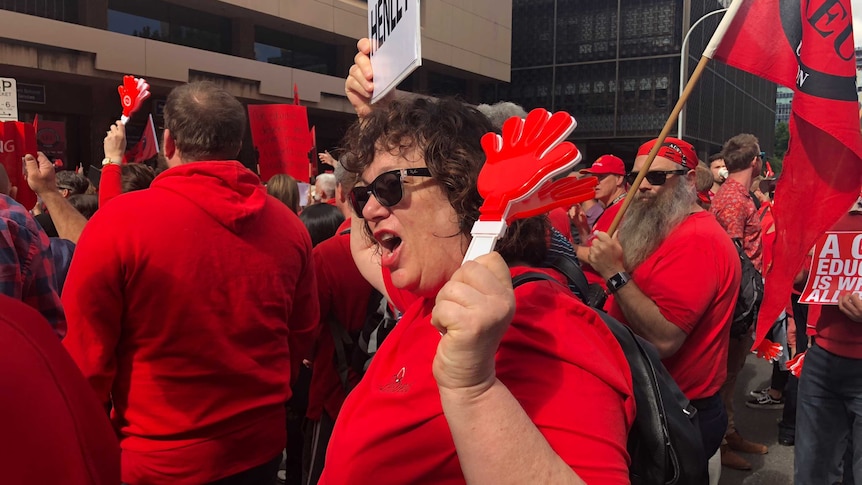 A teacher dressed in red chants at the rally.