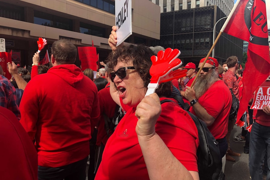 A teacher dressed in red chants at the rally.