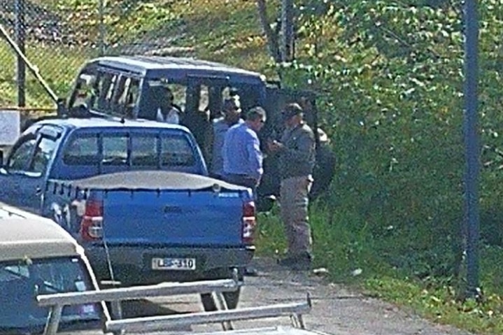 Staff discuss the ongoing standoff at the gates of the refugee centre.