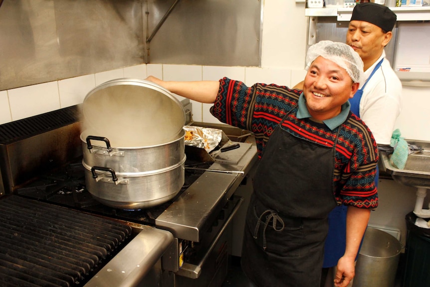 Two members of the Tasmanian Bhutanese community cooking in the community kitchen