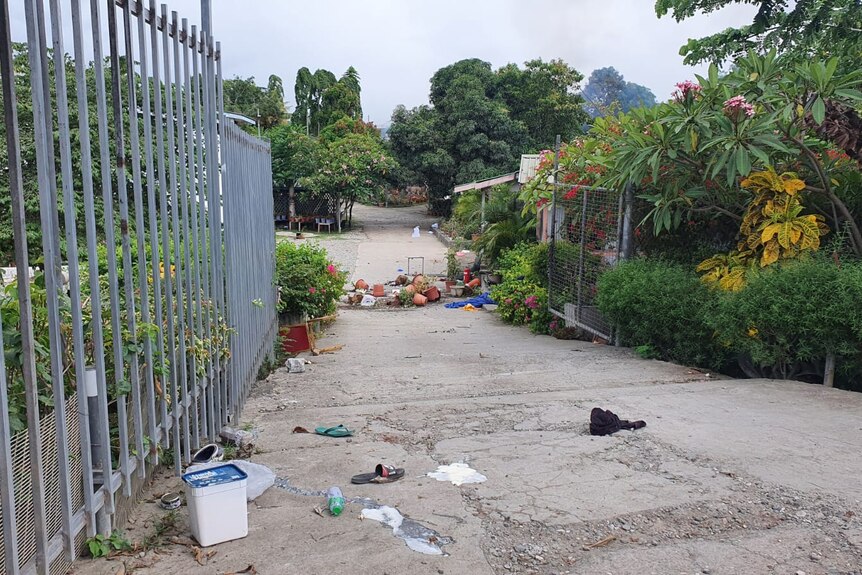 Rubbish is scattered on the pavement outside a gate near Manessah Sogavare's property.