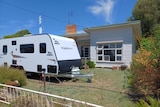 A caravan on the front lawn of a single-storey house in Rochester.