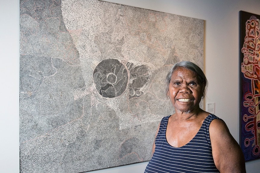 Matjangka Norris in front of her artwork Ngura Pilti