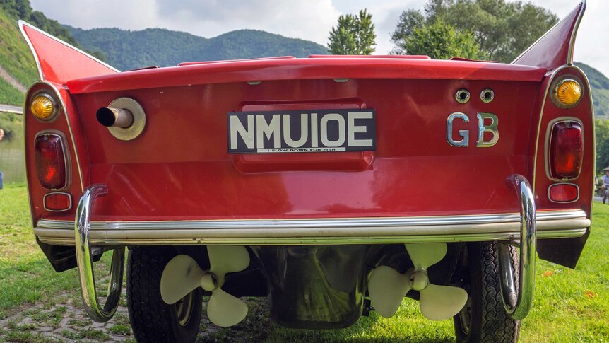 The rear of a red amphibious car showing two propellers and a number plate.