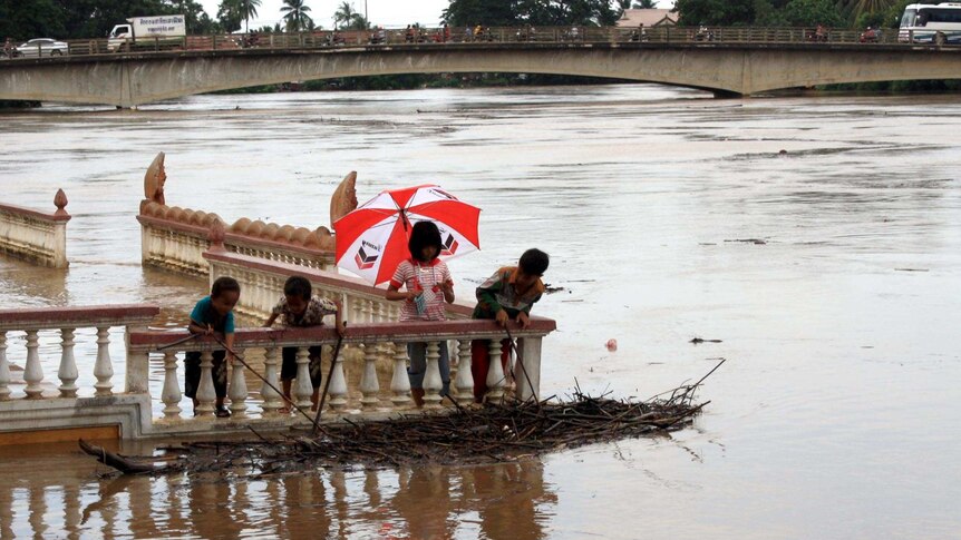 Children investigate some of the debris in the flooded Sangkae River in Battambang.
