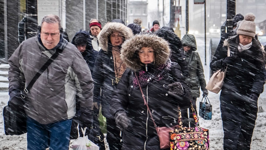 Commuters walk through snow in Chicago
