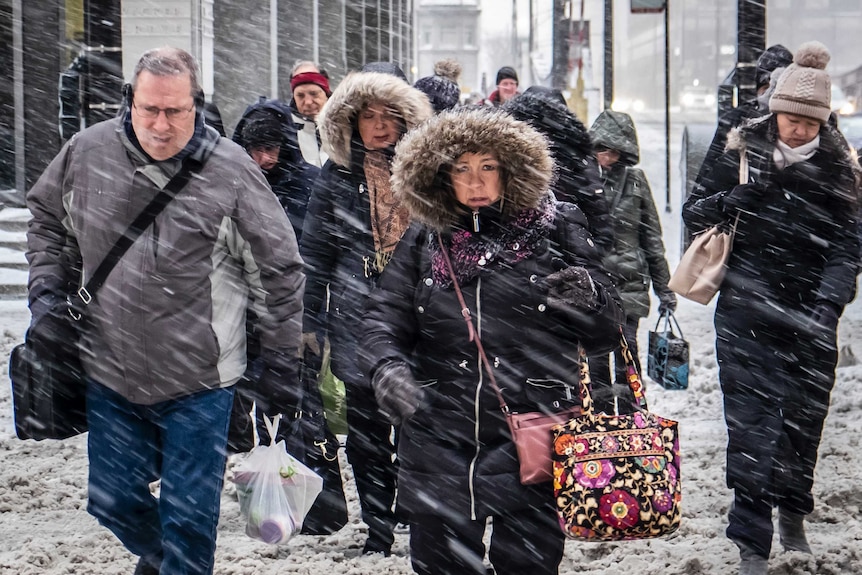 Commuters walk through snow in Chicago