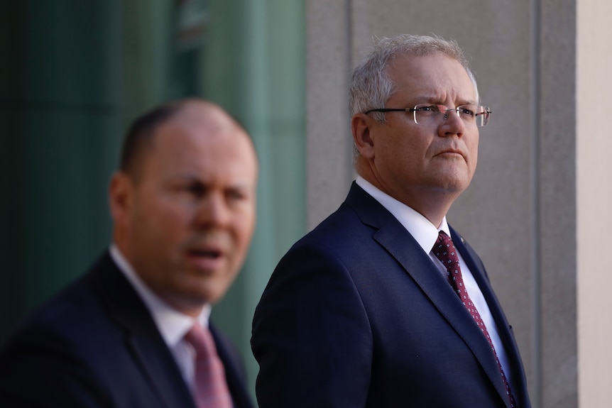 Scott Morrison looks into the distance while listening to Josh Frydenberg at a joint press conference