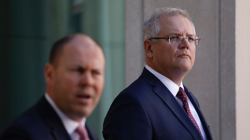 Scott Morrison looks into the distance while listening to Josh Frydenberg at a joint press conference