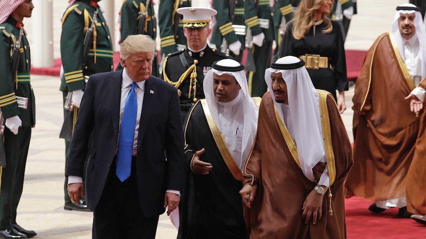 Donald Trump walks with Saudi officials on the red carpet on the tarmac of the international airport in Saudi Arabia