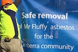 A worker fences off one of the first Mr Fluffy asbestos homes to be demolished.