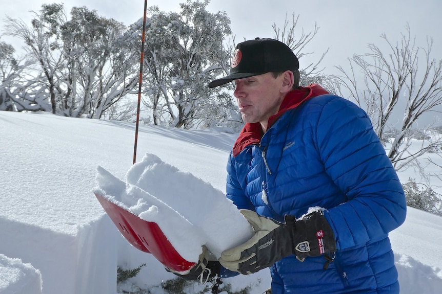 a man with a shovel of snow