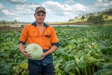 Farmer Mitch Brimblecombe in a paddock holding a pumpkin at Kalbar on the Scenic Rim in Southern Queensland, February 2021.