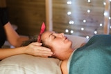 Woman lays on massage table getting a facial in a story about lymphatic drainage facial massages and do they work
