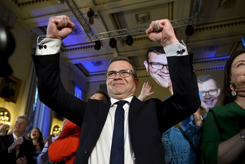 Petteri Orpo raises his arms in victory on election night. 