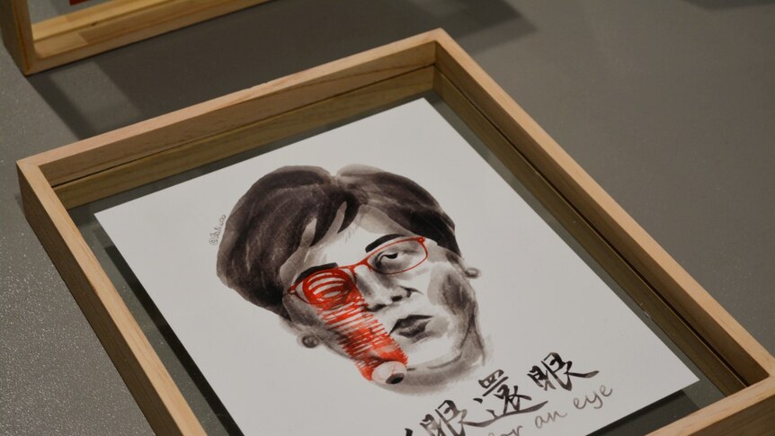 A watercolour illustration of Carrie Lam with glasses and a popped eyeball sits in a transparent wooden frame.