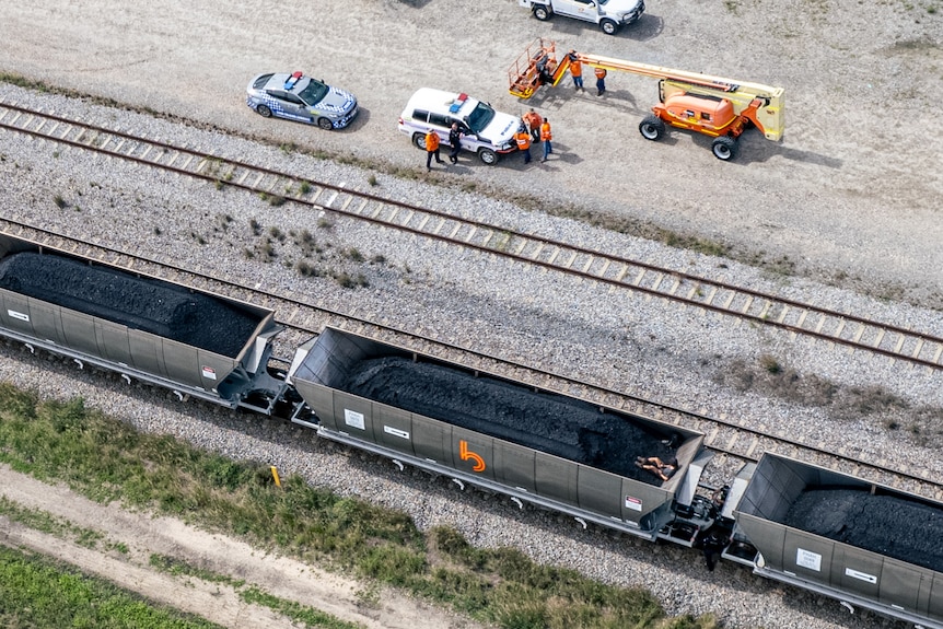 Aerial shot of a man in a coal wagon and police on scene.