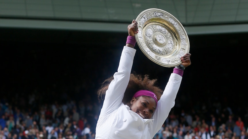 Serena Williams jumps with her trophy after defeating Agnieszka Radwanska in their women's final tennis match at Wimbledon