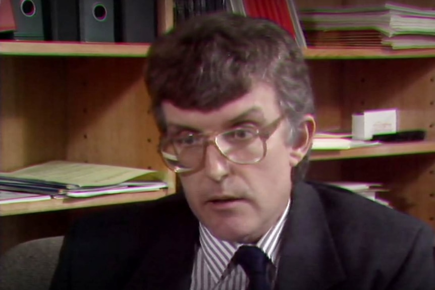 Harry Akers in glasses and suit.