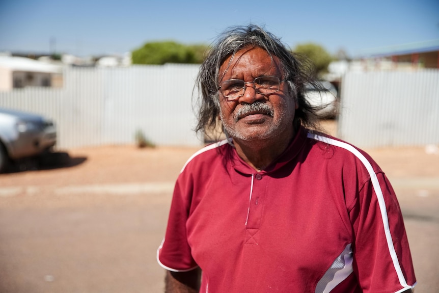 An Aboriginal man with a Coober Pedy street in the background