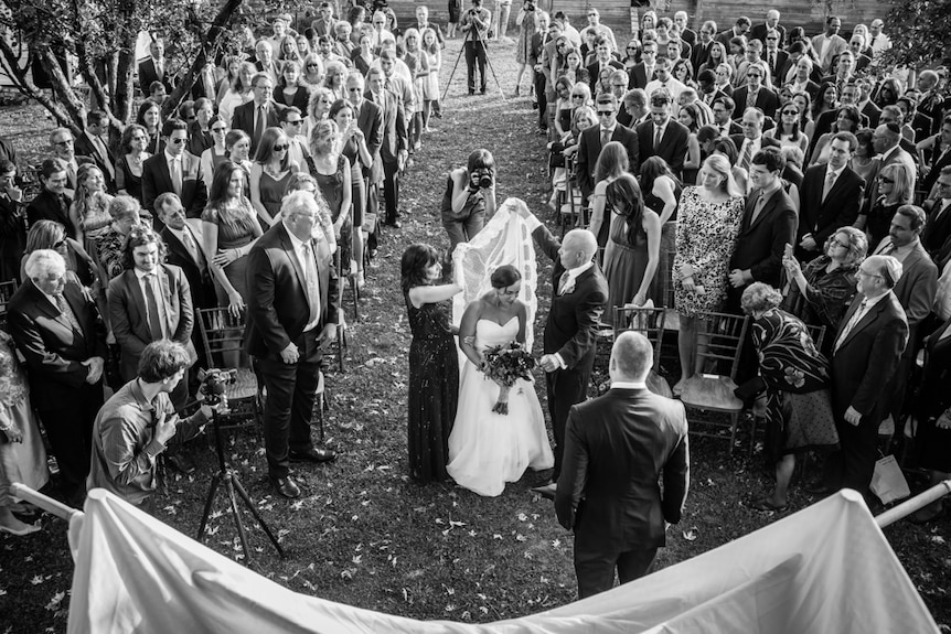 Nancy Borowick stands between her parents at her wedding, at the end of the aisle.