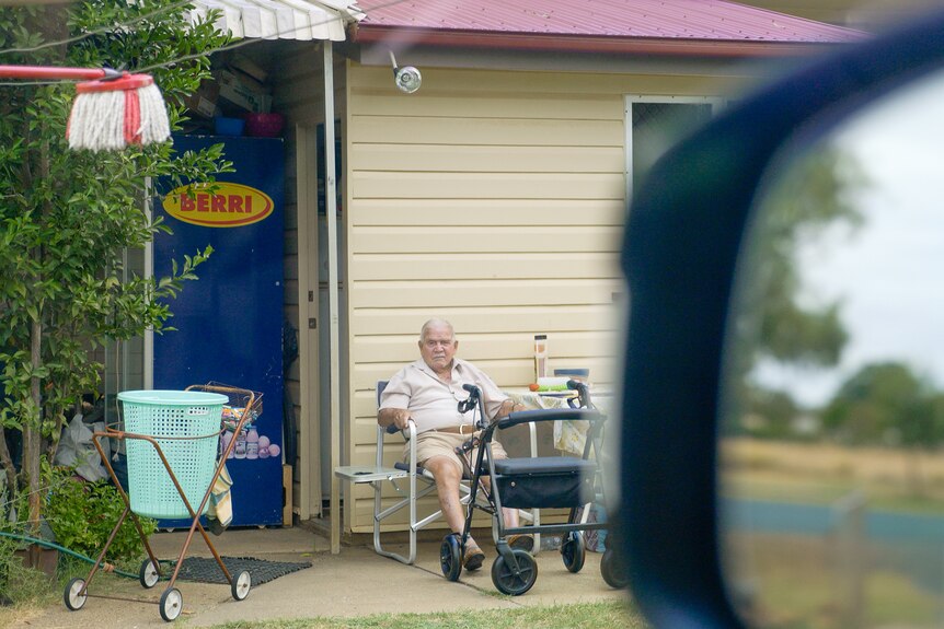 Kevin Waters sits in a chair outside his house in St George, Queensland, March 2024.