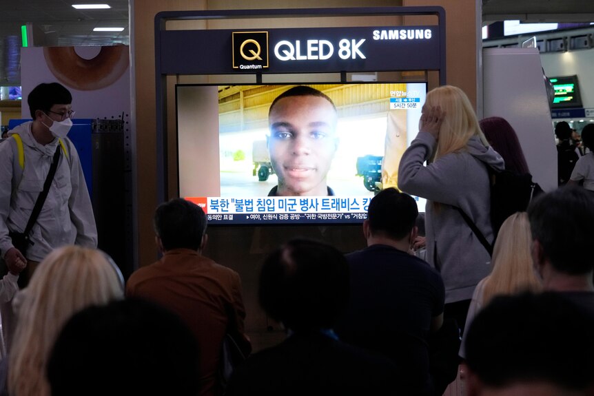 A TV screen shows a file image of American soldier.