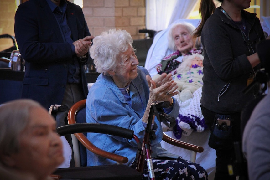 A lady dancing, surrounded by other residents