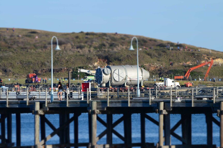 A Coffs Harbour crowd watches on as a 141-tonne heat exchanger gets loaded onto a barge bound for WA.