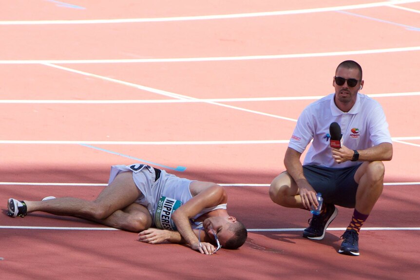 Athlete lays on the track with exhaustion.