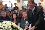 Matthew Barclay's father Steve places memorabilia on top of his coffin.