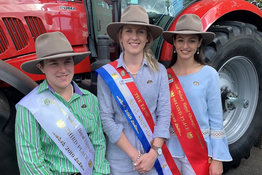 Three young woman wearing their Showgirls sashes at the Royal Easter Show