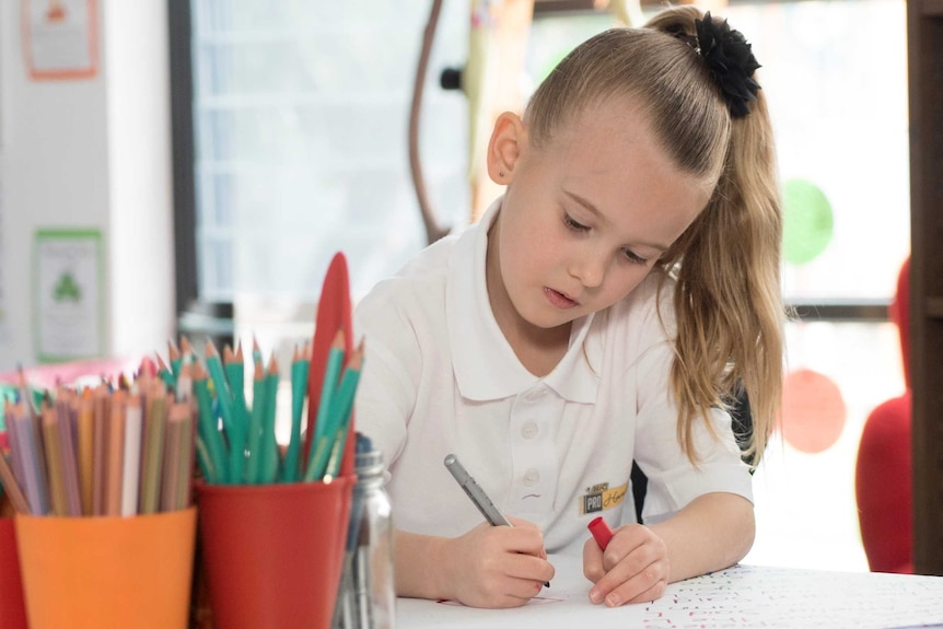 Young girl writing at school.